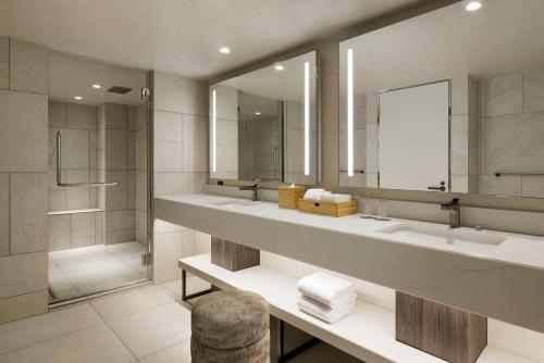 a bathroom with two sinks and a shower at Courtyard by Marriott Tokyo Ginza Hotel in Tokyo