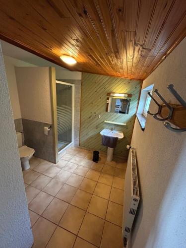 - une salle de bains avec lavabo et toilettes dans l'établissement Camping du Château, à Granges-sur-Vologne