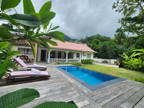 a villa with a swimming pool and a house at Kaz Memel in Beau Vallon
