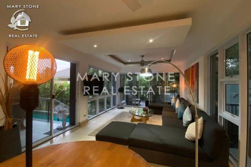 sala de estar con sofá negro y mesa en 4BR - Tropical Garden Pool Villa en Koh Samui