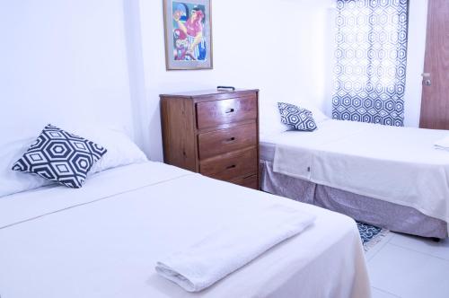 a bedroom with two beds and a dresser at Casa Lucia in Managua