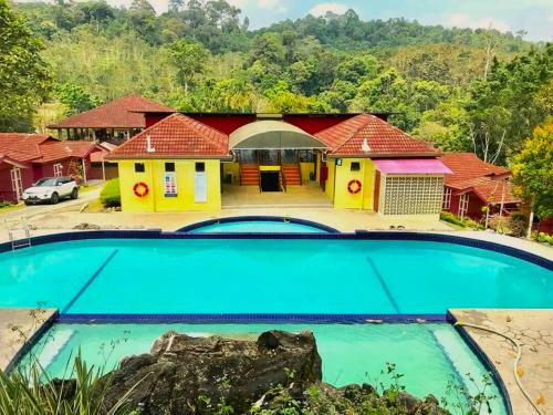 uma casa com uma grande piscina em frente em LiLLA Hilltop Retreats Janda Baik formerly known as Serene Resort em Bentong