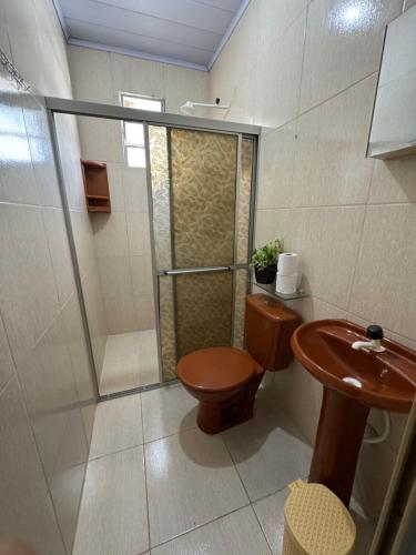 y baño con ducha, aseo y lavamanos. en Apt com ótima localização, com Wi-fi, próximo do Shopping e Aeroporto en Manaos