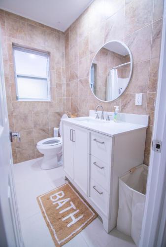 a bathroom with a sink and a mirror and a toilet at CasaHelena Poolside Paradise,Heated Pool,5min to Beach,IRB Clearwater,BBQ in Largo