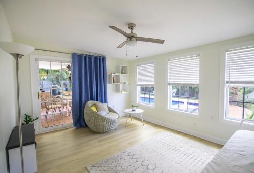 a living room with a ceiling fan and blue curtains at CasaHelena Poolside Paradise,Heated Pool,5min to Beach,IRB Clearwater,BBQ in Largo