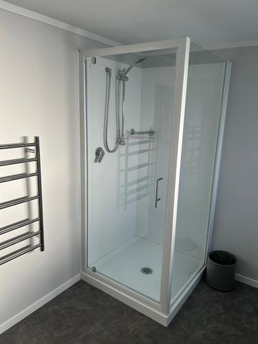 Una ducha de cristal en una habitación con en Team Mac Retreat en Rotorua