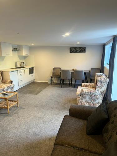 een woonkamer met een bank en een tafel bij Team Mac Homestay in Rotorua
