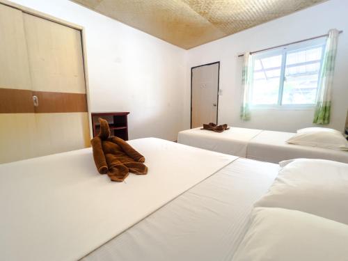 sypialnia z 2 łóżkami i misiem na łóżku w obiekcie Lux Guesthouse w Ko Phi Phi