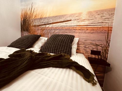 een slaapkamer met 2 bedden en een schilderij aan de muur bij Studio Duinenzicht in Koksijde