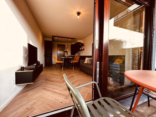 een kamer met een tafel en stoelen en een woonkamer bij Studio Duinenzicht in Koksijde