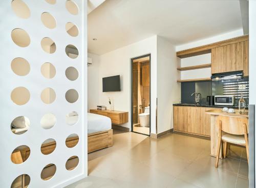 a hotel room with a bed and a kitchen at MIHN SUITES BEN THANH in Ho Chi Minh City