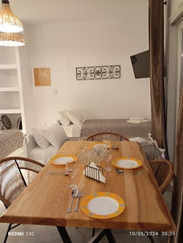 a wooden table in a living room with plates and glasses at Sea melody tinos 3 in Agios Sostis