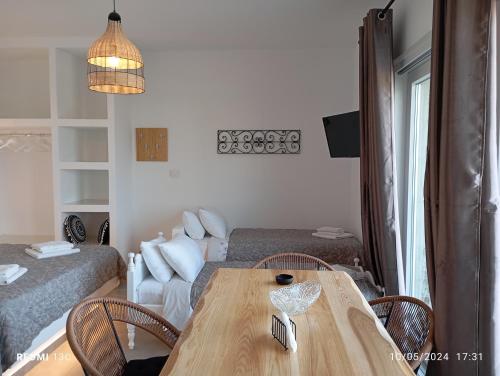 a living room with a wooden table and a bed at Sea melody tinos 3 in Agios Sostis