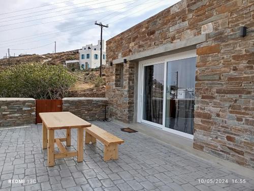 a wooden bench sitting in front of a brick building at Sea melody tinos 3 in Agios Sostis
