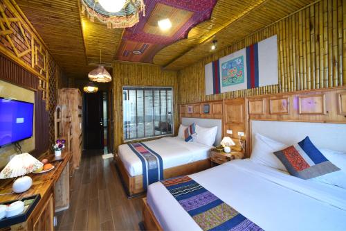 a bedroom with two beds and a flat screen tv at Sapa Nature View Hotel in Sa Pa