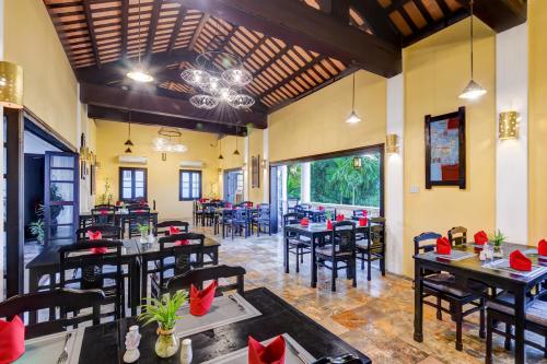 a restaurant with tables and chairs in a room at Hoi An Ancient House Resort & Spa in Hoi An