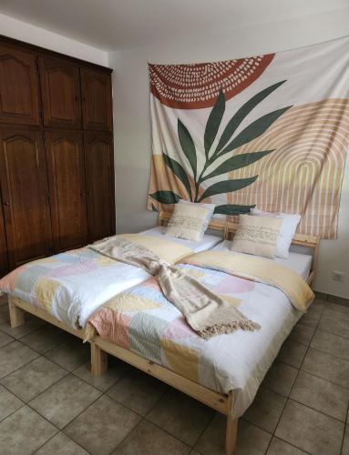 une chambre avec un lit avec un tableau sur le mur dans l'établissement Villa entière au calme, à Soufflenheim