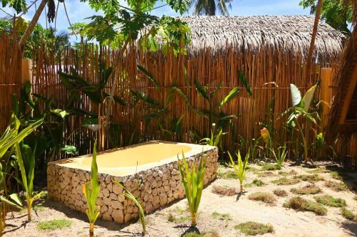 una bañera de piedra sentada frente a una valla en Pretty Jungle Siargao, en San Isidro
