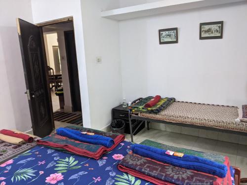 a room with two beds and a table with pillows at Siderbhan Homestay in Chikmagalūr