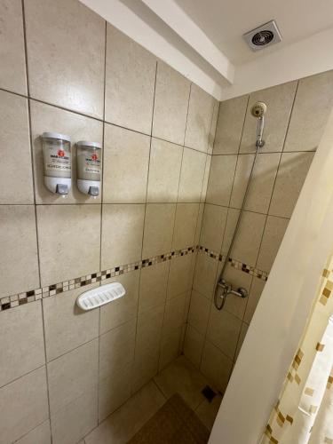 a bathroom with a shower with two buckets at Rincón Montañas del Sur in Ushuaia
