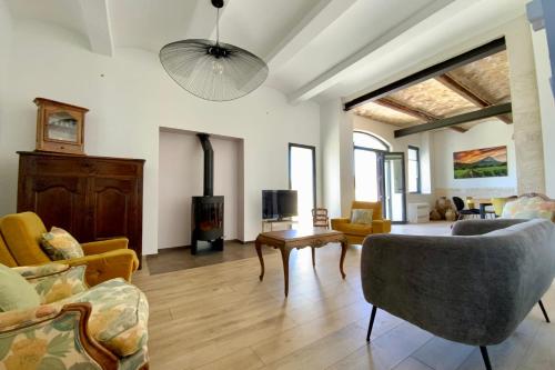 un salon avec un canapé et une cheminée dans l'établissement GROOMI The winegrower- Swimming pool bowling alley and air conditioning !, à Beaulieu