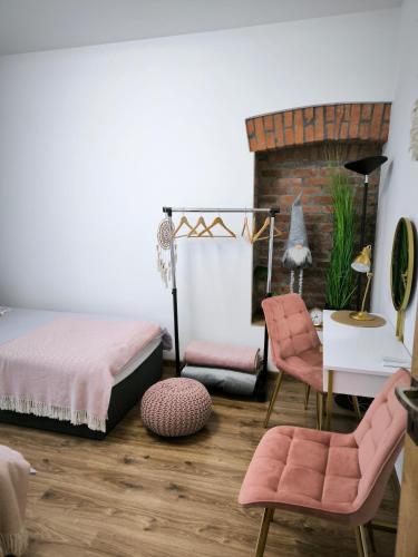 a bedroom with a bed and a table and chairs at Dawna Mleczarnia Apartamenty SOSNOWY in Nowa Ruda
