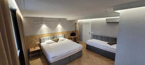 1 dormitorio con 2 camas y espejo en Hotel & Restauracja Wróblewscy, en Karniewo
