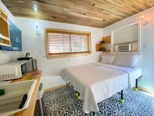 a small bedroom with a bed and a microwave at WeebiII in New Orleans