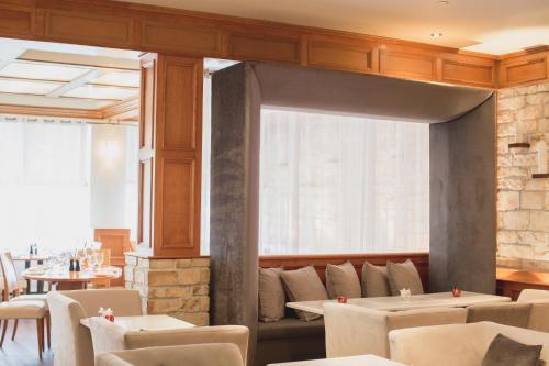 a dining room with tables and chairs and a window at Hôtel Le Bonne Entente in Quebec City