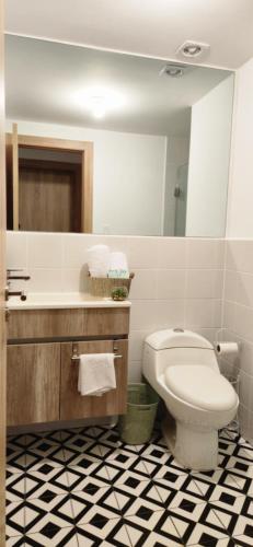 a bathroom with a toilet and a sink and a mirror at El Refuegio in Guatemala