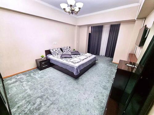 ein Schlafzimmer mit einem Bett und einem TV in der Unterkunft City Center Apartment 1 in Taschkent