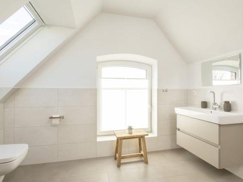 ein Bad mit einem Waschbecken, einem WC und einem Fenster in der Unterkunft Norda - Langeoog in Langeoog