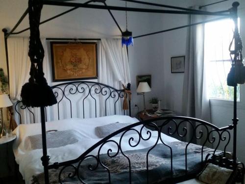 1 dormitorio con cama negra con dosel y ventana en Villa Naranjo Comfortable holiday residence en L'Alfas del Pi