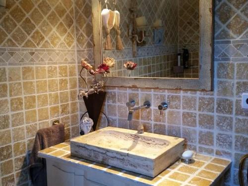 y baño con lavabo de piedra y espejo. en Villa Naranjo Comfortable holiday residence en L'Alfas del Pi