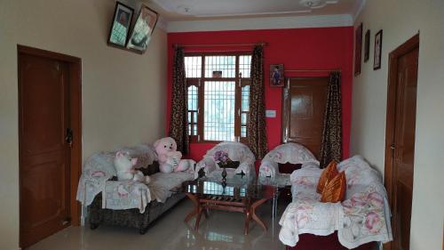 a living room with chairs and a table with dolls at Kanta riverside Home stay in Pālampur