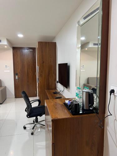 an office with a desk with a chair and a mirror at Hotel Pasupala Inn in Anantapur