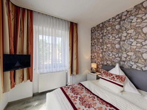 ein Schlafzimmer mit einem Bett und einer Steinmauer in der Unterkunft Stad Vakantiehuis Daun in Daun