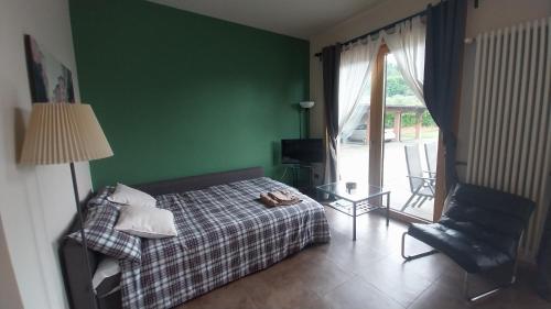 - une chambre avec un lit, une chaise et une fenêtre dans l'établissement Appartamento Franciacorta, à Cazzago San Martino