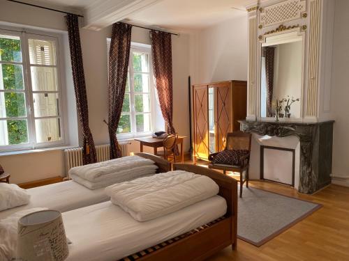 une chambre avec deux lits et une cheminée dans l'établissement Reveries a l'Authie, à Auxi-le-Château
