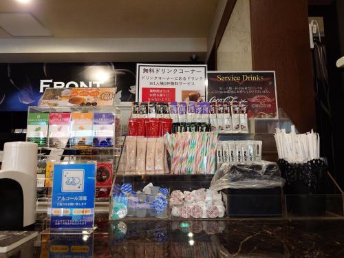 a store counter with a display of food and drinks at ホテル カーシュ Cache 男塾ホテルグループ in Himeji