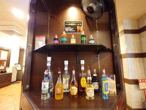 a display of bottles of alcohol on a shelf at ホテル カーシュ Cache 男塾ホテルグループ in Himeji
