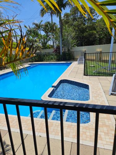 巴里納的住宿－巴利納殖民汽車旅館，一个带黑色围栏和蓝色游泳池的游泳池
