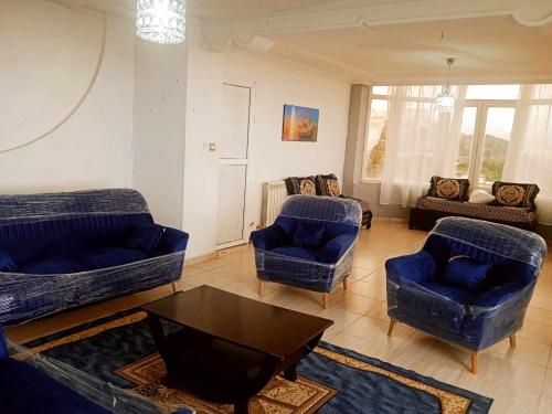 a living room with blue couches and a coffee table at Yakoub in Skikda