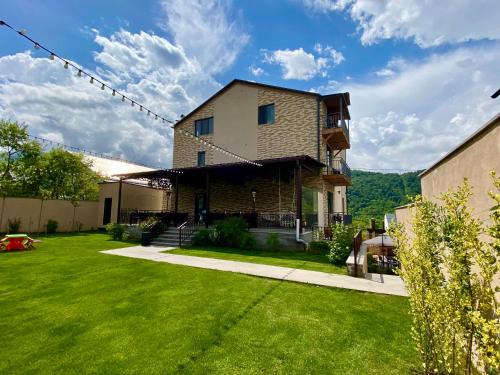 a house with a yard with green grass at Aurelia Hotel & Restaurant in Dilijan
