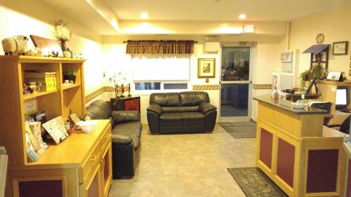 a living room with couches and a kitchen and a living room at Crossfield Country Inn in Crossfield