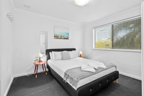 biała sypialnia z łóżkiem i oknem w obiekcie Apartment 10 Burswood w mieście Perth