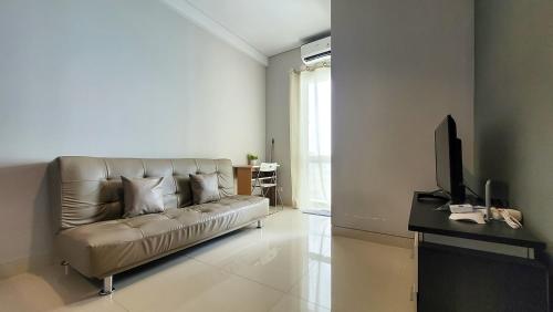 a living room with a couch and a television at Palam Mansion at Apartment One Residence in Batam Center