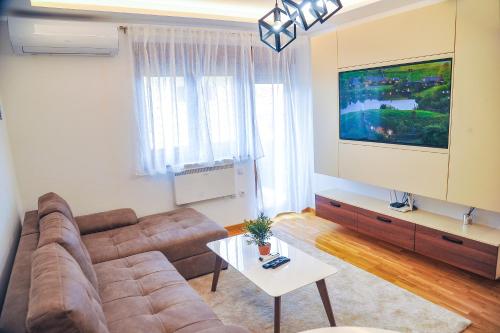 a living room with a couch and a flat screen tv at Zlatibor Argonath Relax&Spa in Zlatibor