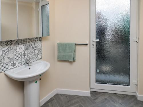 a bathroom with a sink and a shower at Sunshine Cottage in Morpeth