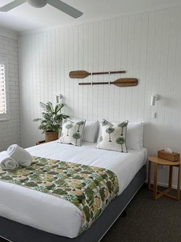 a bedroom with a large white bed with pillows at Mollymook Seascape Motel and Apartments in Mollymook